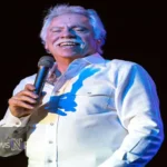 Joe Bonsall, tenor singer of The Oak Ridge Boys, performing on stage with his signature energy and enthusiasm.