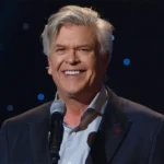 Ron White Net Worth: Comedian Ron White smoking a cigar and holding a glass of scotch on stage